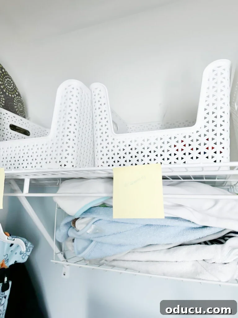 Elevate Your Nursery: Printable Basket Labels for Stylish Organization 6 Neatly labeled white storage baskets on a baby nursery closet shelf, showcasing organized baby essentials