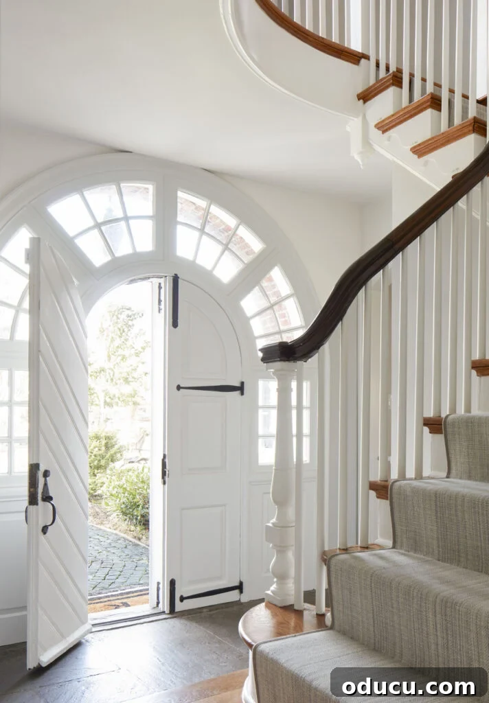 A stunning Main Line Pa home featuring an elegant arched entry door, inviting and beautifully designed.
