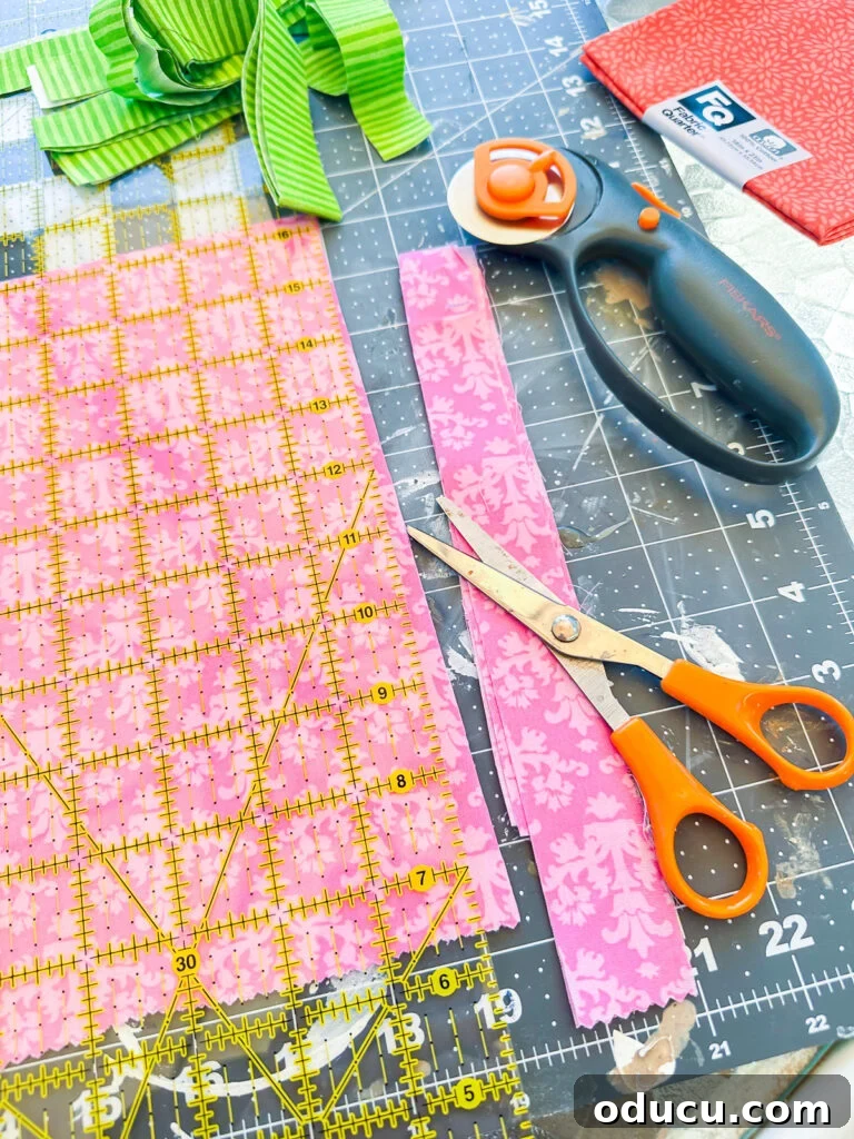 Cutting out strips of fabric with a rotary cutter and quilt ruler.